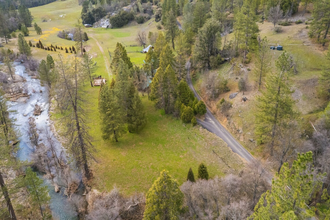 Kowana Valley Cabins next to Bull Creek with a camping meadow, dance floor, and outdoor kitchen